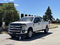A white 2020 Ford F-350 SD pickup truck parked with chrome accents and a spacious bed