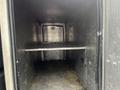 An empty cargo area of a 2008 Mitsubishi Fuso FE180 with metal walls and a single horizontal shelf