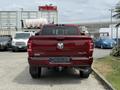 A red 2024 RAM 3500 pickup truck viewed from the rear with a visible tailgate and the RAM logo centered on the back