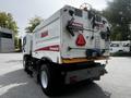 A 2012 Autocar Xpert truck with a rear-mounted body featuring safety signage and a caution label