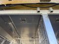 A close-up view of the interior of a 2007 Chevrolet Express showcasing metal shelving with small holes and wire mesh partitions