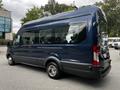 A blue 2017 Ford Transit 350 with a high roof and large windows parked at an angle showcasing its side profile and rear design