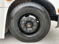 Close-up of the wheel and tire of a 2015 Spartan School Bus featuring a black rim with exposed lug nuts and a Yokohama tire marked with sizing information