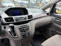 Interior view of a 2014 Honda Odyssey showcasing the dashboard with audio controls and gear shift in the foreground
