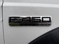 Close-up of a chrome badge on a 2006 Ford F-450 displaying the text F-450 super duty with raindrops on the surface