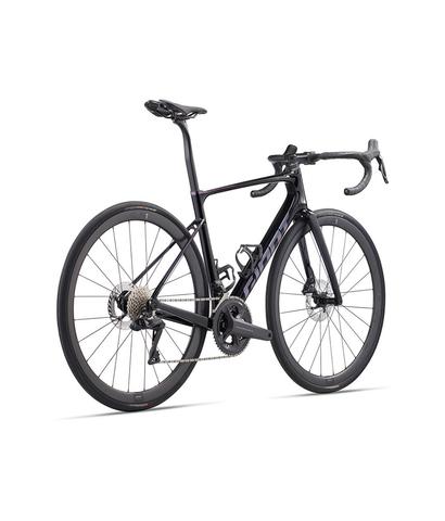 A 2024 Giant Defy Advanced Pro 0 road bike featuring a sleek design with a dark color scheme and advanced components including disc brakes and a modern geometric frame
