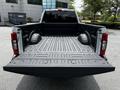 A 2020 Ford F-350 Super Duty pickup truck with an empty bed, featuring a textured liner and wheel well cutouts