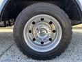 Close-up of a 2016 Ford F-550 wheel showcasing a chrome hubcap with the Ford logo and a rugged tire with tread pattern