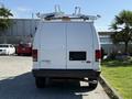 Rear view of a white 2011 Ford Econoline van with a roof rack