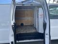A 2022 GMC Savana cargo van with an open back door revealing a spacious interior featuring a wooden floor and a partition on one side