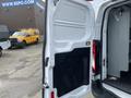 A 2017 Ford Transit van with its rear door open showing the interior space and cargo area