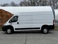 A white 2021 RAM Promaster van with a high roof and long cargo area visible from the side