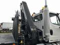 A 2006 Freightliner M2 112 truck with a raised hydraulic mechanism attached to the rear of the vehicle