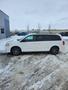 A white 2012 Dodge Grand Caravan parked on a snowy surface with alloy wheels and a side view showing its sliding doors and minivan design