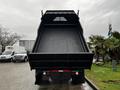 A 2005 GMC C5 Duramax dump truck with its bed raised open showing a flat cargo area and distinct rear features