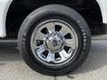 Close-up of a chrome wheel with five spokes and a Firestone tire on a 2010 Ford Ranger