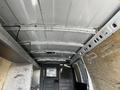 Interior view of a 2015 Chevrolet Express cargo van showing metal ceiling and wooden panels with storage shelves on the sides