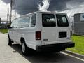 A white 2004 Ford Econoline van viewed from the rear showing its elongated body and large windows