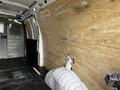 A 2015 Chevrolet Express van with a bare interior space featuring wooden paneling and a partially visible wheel well