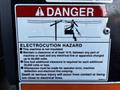 A warning sign detailing electrocution hazards associated with the 2000 JLG 12SP, emphasizing clearance requirements and safety procedures for using the machine