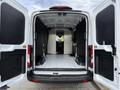 2022 Ford Transit van with open rear doors showing a spacious cargo area with a flat floor and black side walls