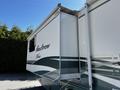 A 2000 Ford Motorhome with a white and teal exterior featuring the name Pace Arrow on the side and a slide-out extension on the left side