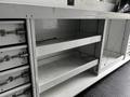 A 2013 Ford Econoline van interior showing shelves and storage compartments with metal handles