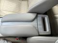 A center console of a 2016 Nissan Murano featuring a grey armrest and a storage compartment with a wood-like finish