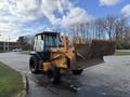 A 2005 Case 570 tractor with a front loader attachment is parked on a paved surface with its bucket raised