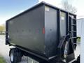A black 2009 Ford LCF 550 truck with a large flatbed container attached featuring side access and a rear ramp for loading and unloading materials