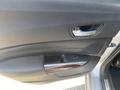 A close-up view of the interior door panel of a 2017 Acura TLX featuring a sleek design with wood accents and a metallic door handle