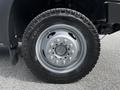 A close-up view of a wheel from a 2016 Ford F-550 featuring a silver rim and a rugged tire with pronounced treads
