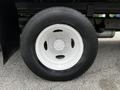 A white wheel with a black tire attached to a Ford E-450 vehicle