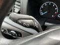 Close-up of a 2022 Ford Transit steering wheel control lever with turn signal and headlight adjustment functions displayed