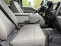 Interior view of a 2020 Ford F-550 showcasing the front seats with a console and seat belts in a gray fabric material