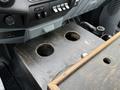 A wooden center console with two cup holder openings in a 2015 Ford F-350 SD