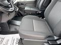 Interior view of a 2023 Ford Transit highlighting the driver and passenger seats with a patterned fabric design and armrests