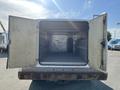 A 2015 Ford F-450 SD with its rear doors wide open revealing a spacious, empty cargo area with a gray floor and metal walls