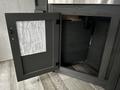 A dark gray cabinet door open to reveal storage space with a list of specifications attached to the inside of the door
