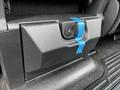 Close-up of a 2024 Ford F-550 control panel with a circular button surrounded by blue tape on a textured surface