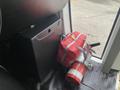 A 2017 Chevrolet Express with a black storage box a red bag and a fire extinguisher placed on the vehicle's floor near the entrance