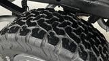 Close-up of a rugged tire with deep treads designed for off-road use mounted on a 2013 Chevrolet Silverado 1500