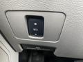 Close-up of a control switch panel in a 2017 Ford F-550 featuring a button for adjusting the seat position and a brake release lever