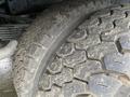 Close-up of two large, rugged tires with deep treads, showing dirt accumulation on the surface, part of a 2014 RAM 5500 truck