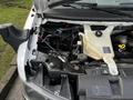 Close-up of the engine compartment of a 2015 Chevrolet Express showing the coolant reservoir and various engine components