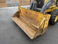 A 2011 John Deere 310SJ 4x4 Wheel Loader with an extended hoe and a 4 in 1 bucket showing a rusty yellow bucket in the foreground