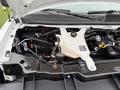 The image shows the engine compartment of a 2014 GMC Savana with various components including a coolant reservoir battery and wiring harnesses visible