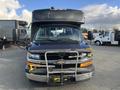 A 2018 Chevrolet Express with a black exterior featuring a front grille and large windshield along with prominent side mirrors and a protective front bar