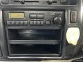 The interior dashboard of a 2004 Toyota Toyoace featuring a radio display with controls and an empty compartment below the radio