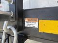 Label on a pintle hook indicating a capacity of 14000 lbs with a warning sign